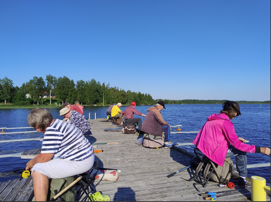 kuvassa on ihmisiä laiturilla pilkkimässä.